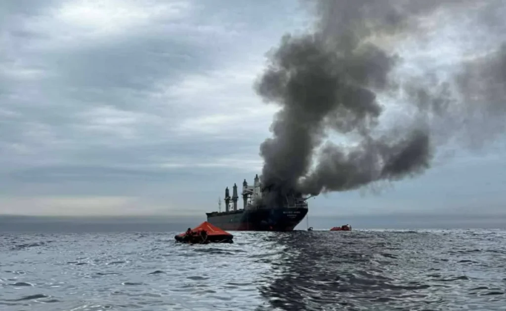 Thai cargo ship Mayuree Naree emitting black smoke after projectile attack in Strait of Hormuz
