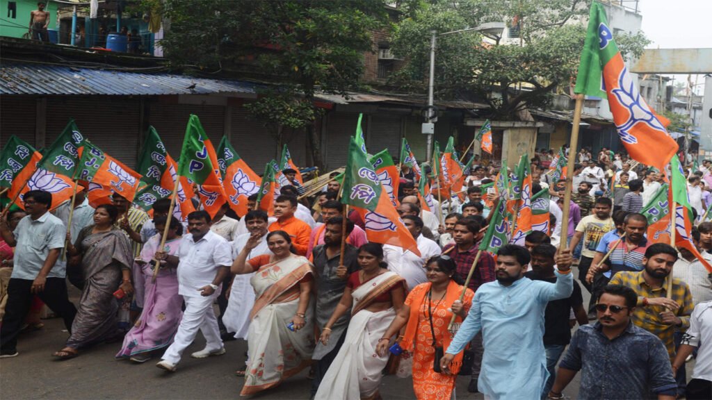 “West Bengal political map glowing in saffron color wave, BJP flag rising high over the state, dramatic lighting, election mood, crowd silhouettes cheering, digital news style, high contrast”